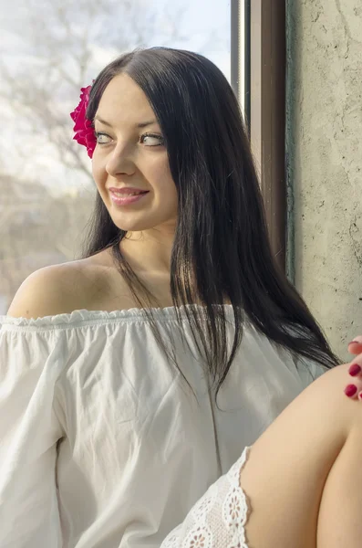 Chica con el pelo largo en una camisa de lino en la ventana —  Fotos de Stock
