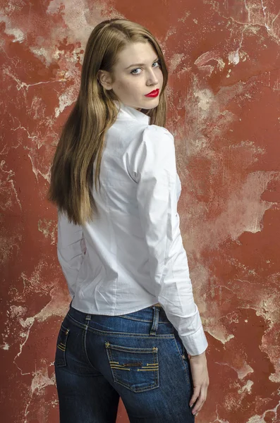 Young slim beautiful young blond woman with long legs and hair in shirt and jeans — Stock Photo, Image