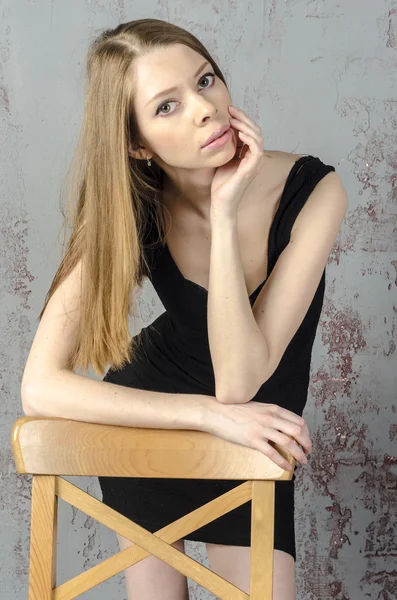 Szczupły piękne Ruda dziewczyna w czarnej mini sukience z krzesła — Zdjęcie stockowe