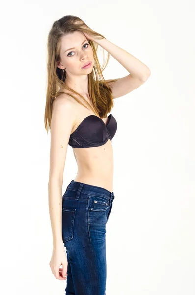 Slim blonde meisje in jeans en beha — Stockfoto