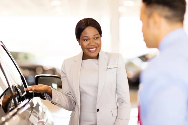 Car dealer presenting new vehicle — Stock Photo, Image