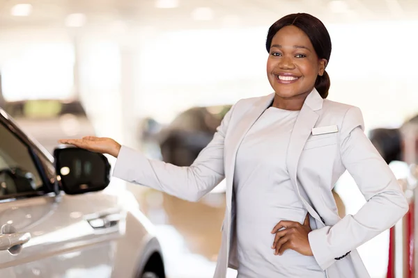 Car saleswoman presenting new vehicle — Stock Photo, Image