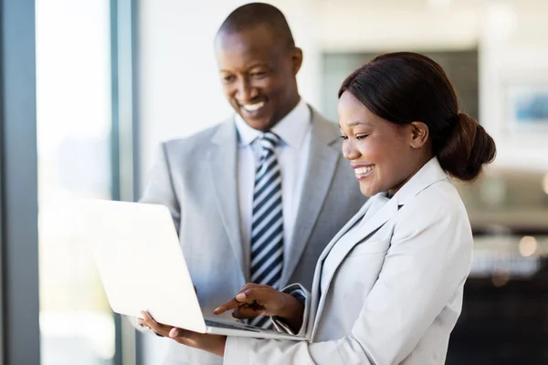 Workers with laptop inside car showroom — Stock Photo, Image