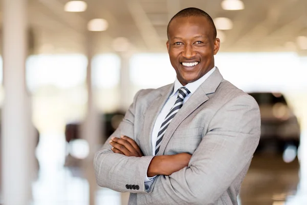 Car dealership principal in vehicle showroom — Stock Photo, Image