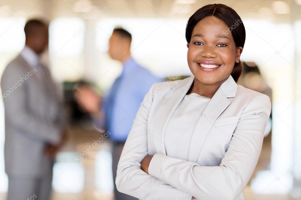 saleswoman standing inside vehicle showroom