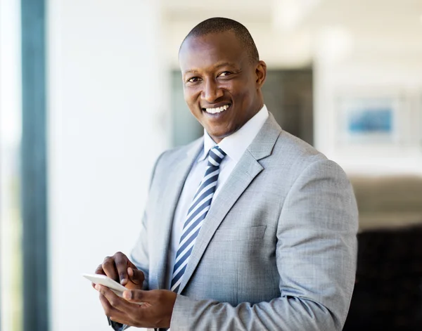 Hombre de negocios con teléfono inteligente en la oficina — Foto de Stock