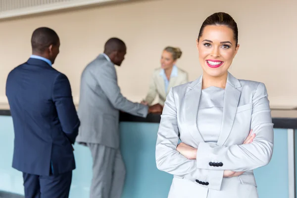 Zakenvrouw die permanent bij de receptie van het hotel met collega 's — Stockfoto