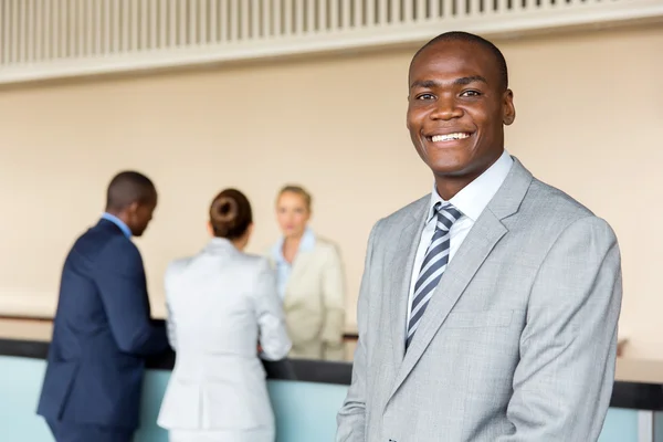 Businessman standing at hotel reception — Stock Photo, Image