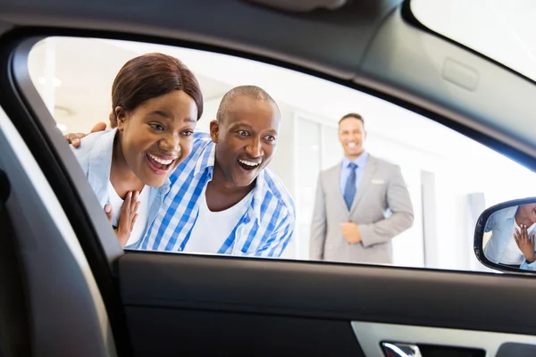 Concessionário de veículos vendendo carro para casal — Fotografia de Stock