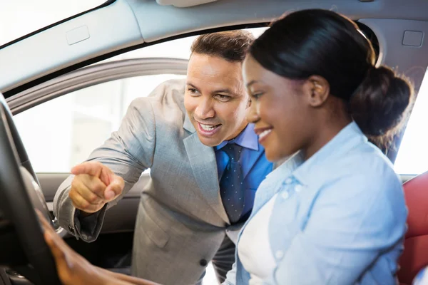 Salesman showing car to female customer — Stock Photo, Image