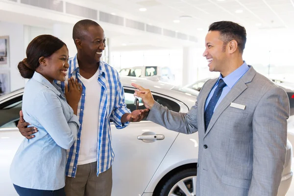 Salesman handing over key to couple — Stock Photo, Image