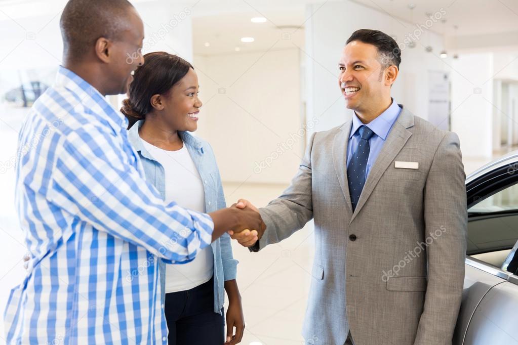 salesman handshaking with couple