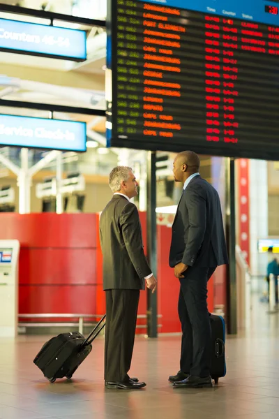 Businessmen in front of information board — Stock Photo, Image