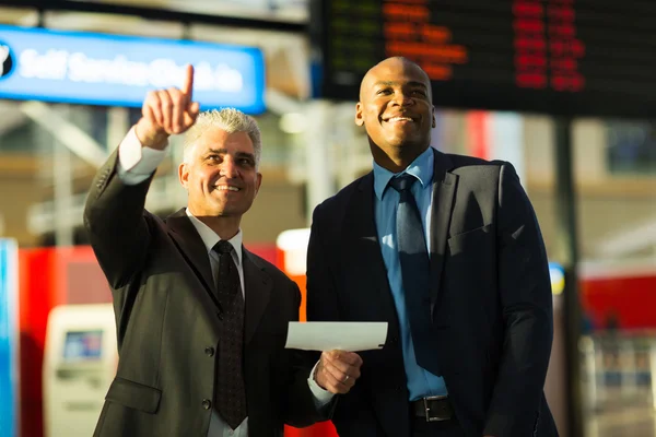 Travellers pointing at information board — Stock Photo, Image