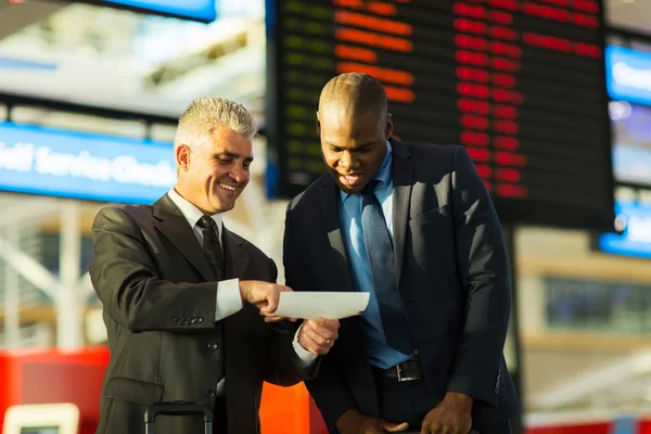 Business travellers looking at air ticket — Stock Photo, Image