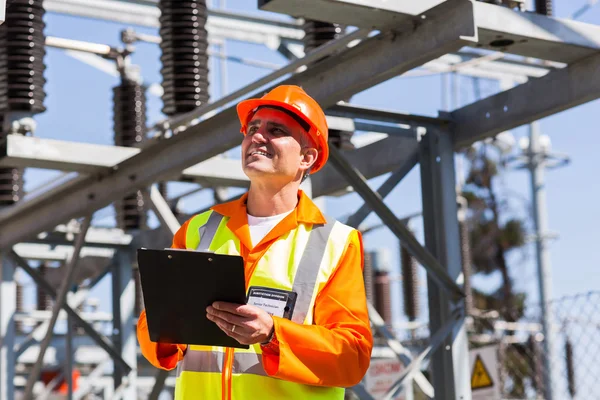 Electricista de mediana edad sujetando portapapeles — Foto de Stock