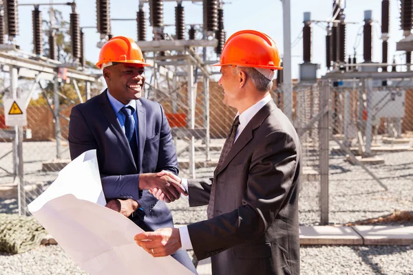 Geschäftsleute beim Händeschütteln in Umspannwerk — Stockfoto