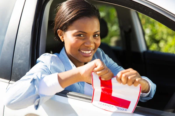 Girl in a car tearing her L sign — Stock Photo, Image
