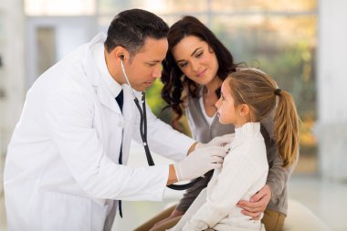 Doktor küçük kızı muayene ediyor.