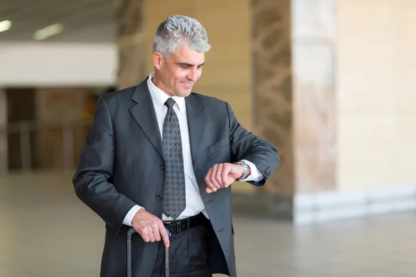 Businessman checking time at airport — Stock Photo, Image