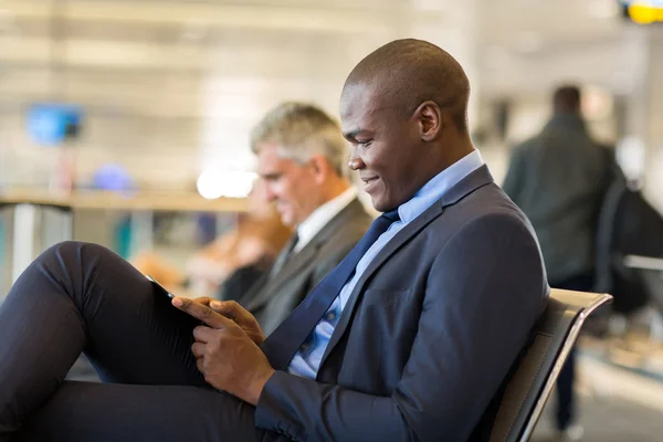 Αφρικανική επιχειρηματίας χρησιμοποιώντας δισκίο στο αεροδρόμιο — Φωτογραφία Αρχείου