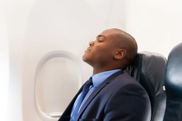 Empresário africano descansando em avião — Fotografia de Stock