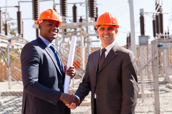 Affärsmän handskakning i transformatorstation — Stockfoto