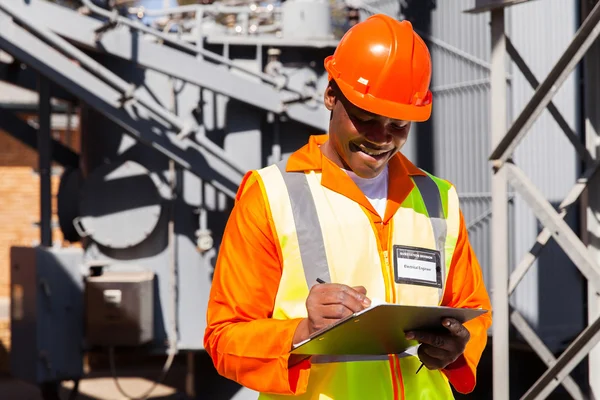 African electrician writing on clipboard — Stock Photo, Image