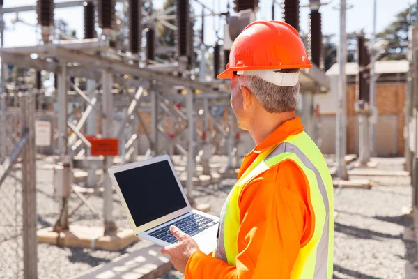 Technicien senior tenant un ordinateur portable — Photo