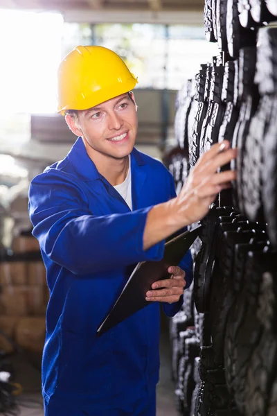 Werknemer tellen voorraden in magazijn — Stockfoto