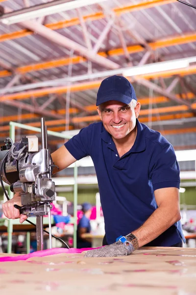 Factory worker using fabric cutter — Stock Photo, Image