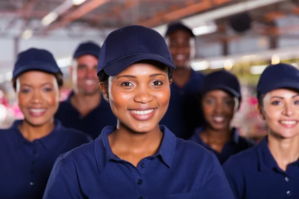 Trabajador de fábrica africano joven con colegas —  Fotos de Stock