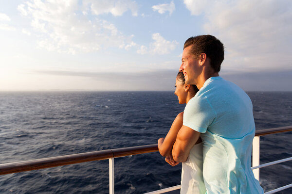 Couple looking at sunrise on cruise ship