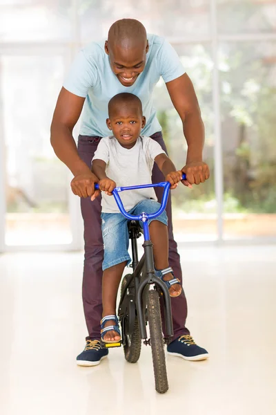 Man helpt zijn zoon om te rijden — Stockfoto