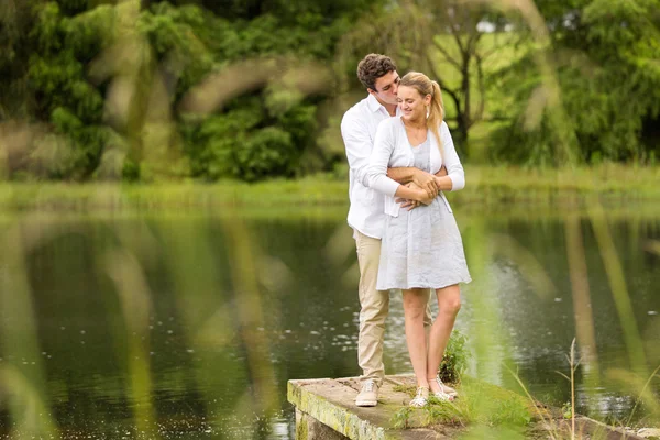 Ungt par stående vid floden — Stockfoto