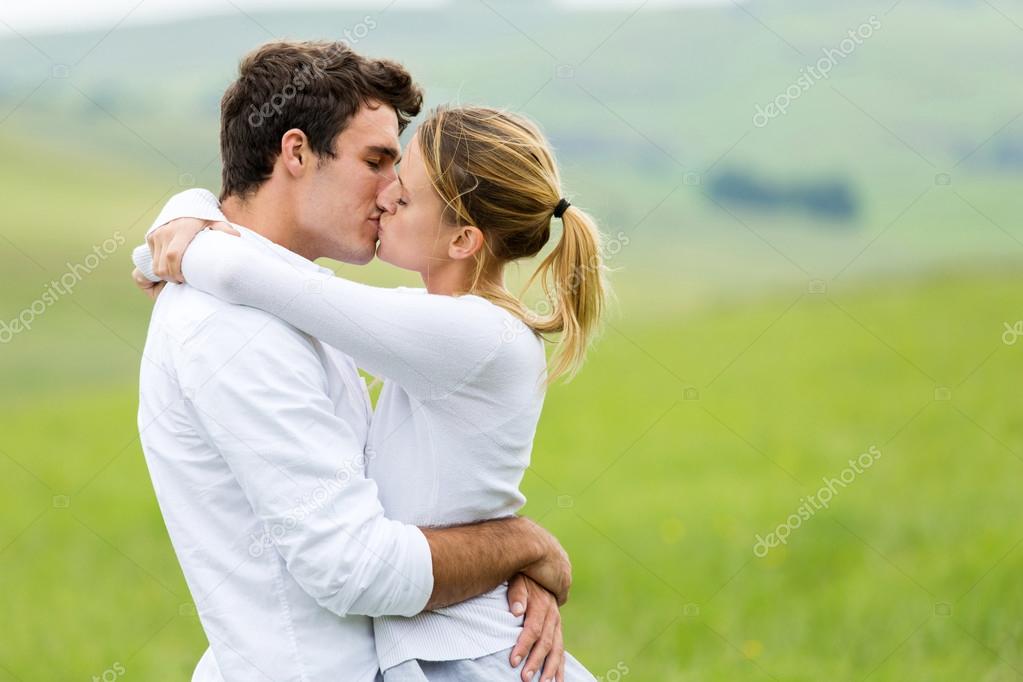 romantic couple kissing on grassland