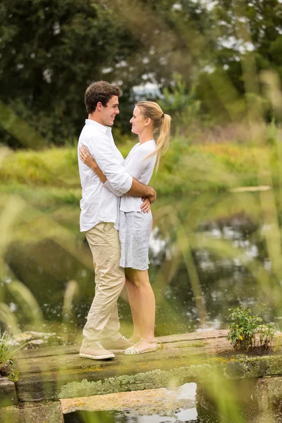 Couple hugging on lake pier — Stock Photo, Image