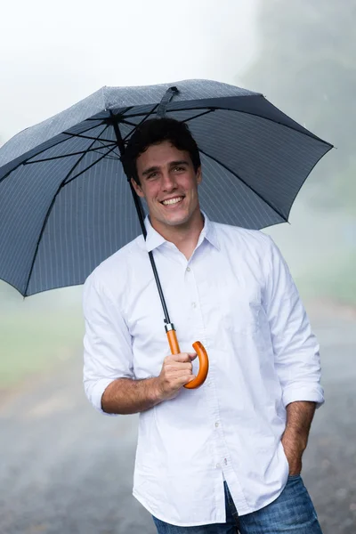 Jeune homme tenant parapluie — Photo