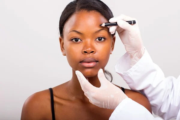 Afrikaanse vrouw voor haar gezicht markering — Stockfoto