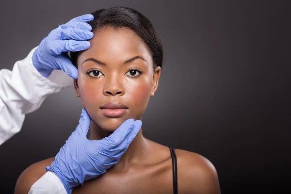 Dermatologue vérifiant la peau du visage de femme — Photo