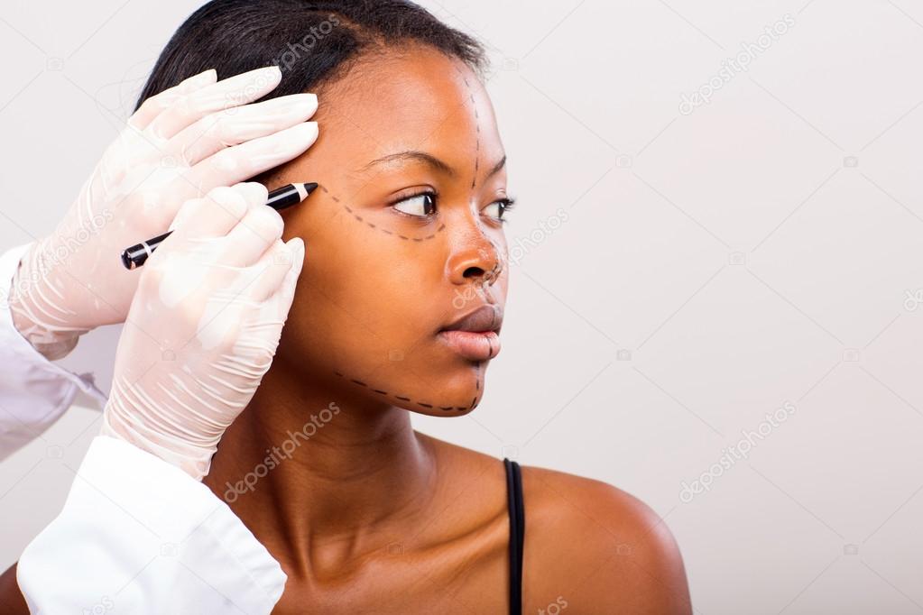 Doctor marking woman face