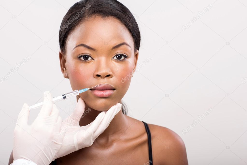 Girl receiving cosmetic injection on her lips