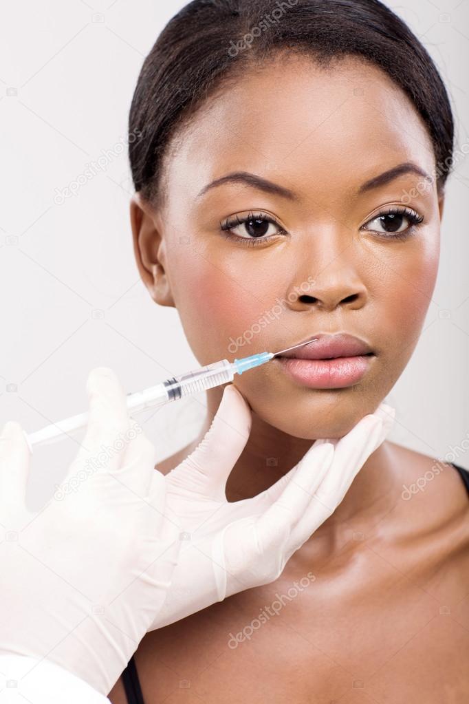 Woman receiving cosmetic injection in her lips