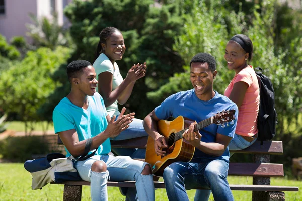 College boy playing guitar for friends — Stock Photo, Image