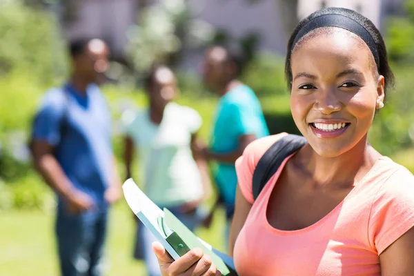 College student holding books on campus — Stock Photo, Image