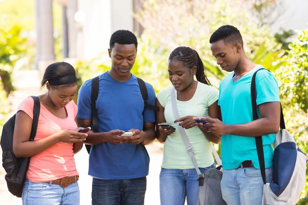 Estudiante universitario usando sus teléfonos celulares — Foto de Stock