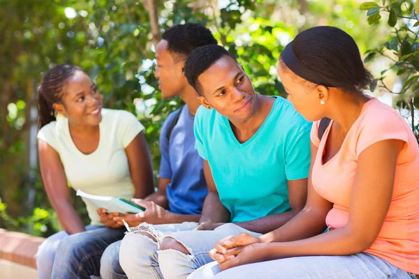 Junge Studenten sitzen im Freien — Stockfoto