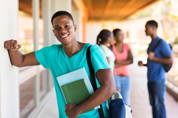 Garçon de collège avec des livres debout par passage — Photo