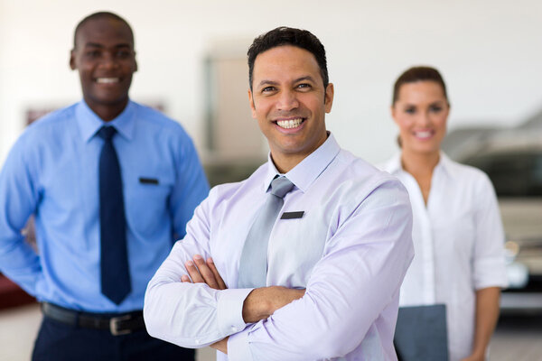 middle aged car salesman with colleagues