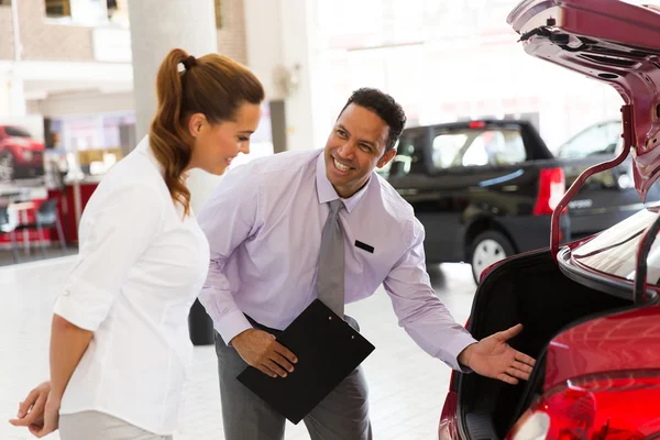 Venditore di auto mostrando nuovo veicolo al cliente — Foto Stock